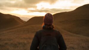 woman pensively looking out at mountains