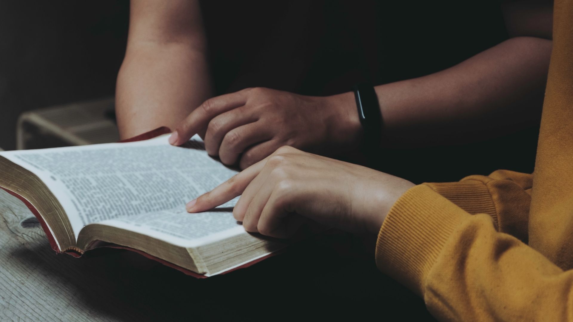 person pointing out scripture in the bible