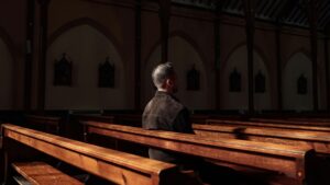 man sitting in church pews